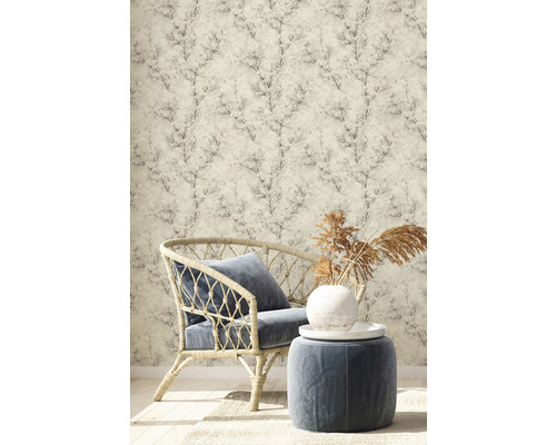 Scène avec fauteuil en rotin, tabouret et papier peint à motif végétal pour un intérieur élégant