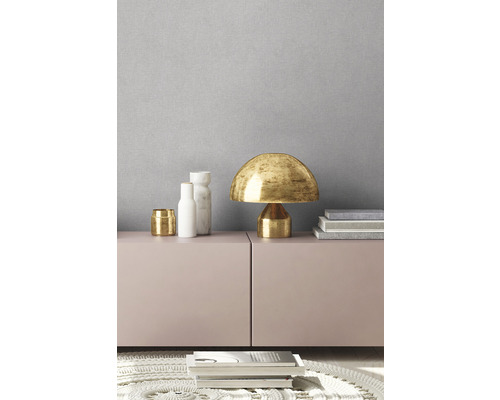 Dekoratives Interieur mit Tischleuchte und Wohnaccessoires auf einem Sideboard