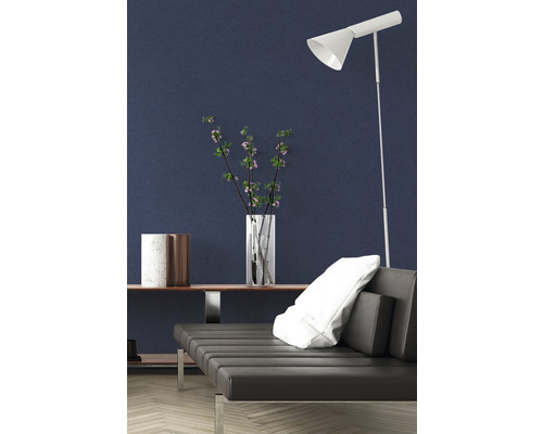 Intérieur moderne avec canapé, lampadaire et objets de décoration devant un mur sombre