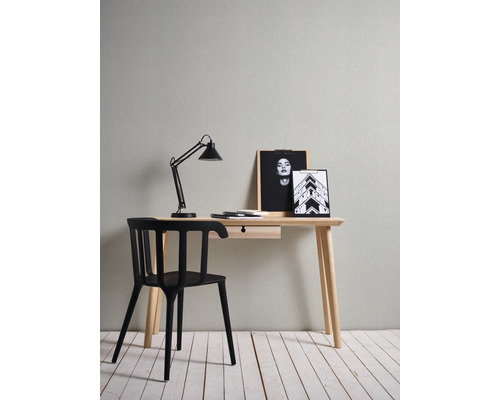 Schreibtisch mit Lampe, Stuhl und dekorativen Bildern in einem Arbeitszimmer