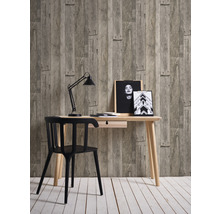 Bureau avec table, chaise, lampe de bureau et décoration devant un papier peint imitation bois
