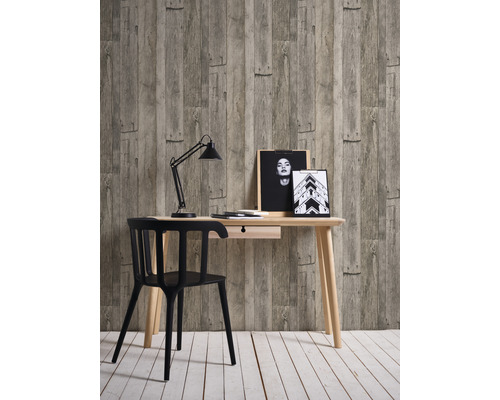 Bureau avec table, chaise, lampe de bureau et décoration devant un papier peint imitation bois