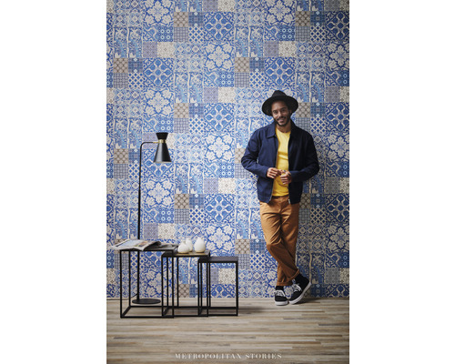 Scène avec un papier peint mural en patchwork, un ensemble de tables d''appoint et un lampadaire.