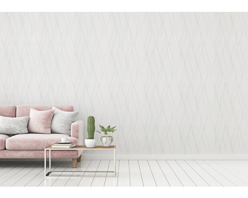 Wohnzimmer mit rosa Sofa, Tisch und gemusterter Tapete für eine helle und freundliche Atmosphäre.