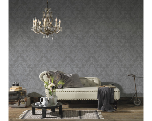 Wohnzimmer mit dekorativer Tapete, Sofa, Teppich und Kronleuchter