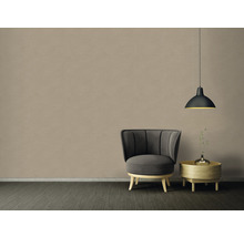 Intérieur avec fauteuil, table d''appoint et suspension devant un mur beige