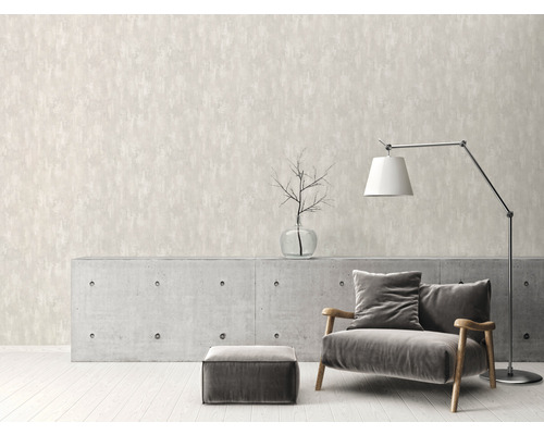 Salon avec papier peint structuré beige, fauteuil, lampe et armoire en béton