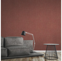 Salon avec papier peint intissé rouge, canapé gris, lampadaire et table d''appoint.