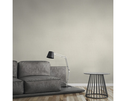 Un salon avec un canapé gris, un lampadaire et une petite table d''appoint.