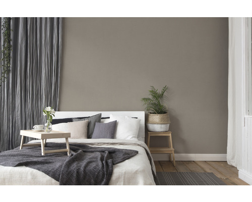 Schlafzimmer mit Bett, Nachttisch, Vorhängen und Dekorationen für eine gemütliche Atmosphäre