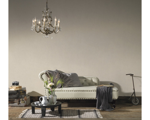 Wohnzimmer mit Kristalllüster, Sofa mit Knopfheftung, kleinem Tisch, Dekoration und Kinderroller