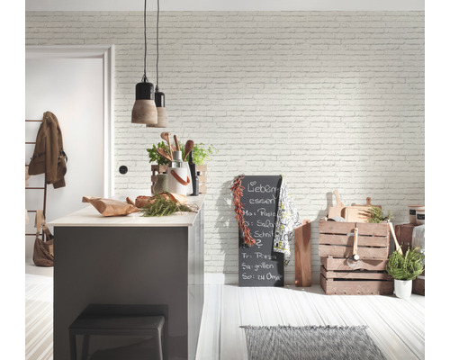 Cuisine claire avec papier peint imitation briques, îlot de cuisine et caisses en bois décoratives