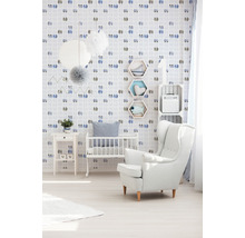 Kinderzimmer mit Kinderbett, Sessel und mit Schuhmotiven verzierter Tapete