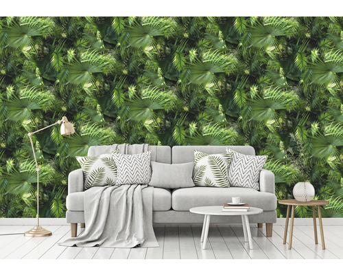 Salon avec canapé devant un papier peint à motif de palmier