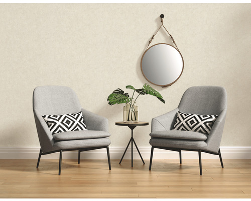Salon avec deux fauteuils gris, une petite table et un miroir rond
