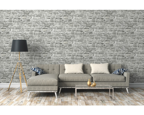 Salon avec papier peint imitation pierre grise, canapé, lampadaire et table basse
