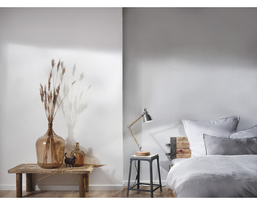 Chambre lumineuse avec lit, lampe de chevet et décoration sur une table en bois