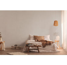 Helles Schlafzimmer mit Bett, Nachttisch, Lampe und Textiltapete