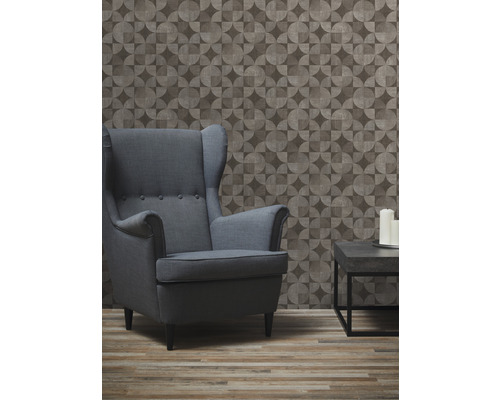 Salon avec fauteuil, table et papier peint géométrique