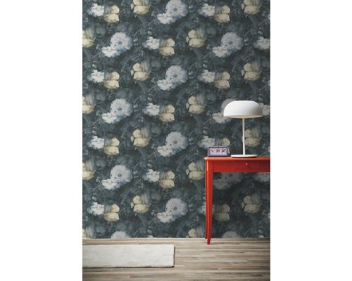 Zimmer mit floral gemusterter Tapete, rotem Tisch und Lampe