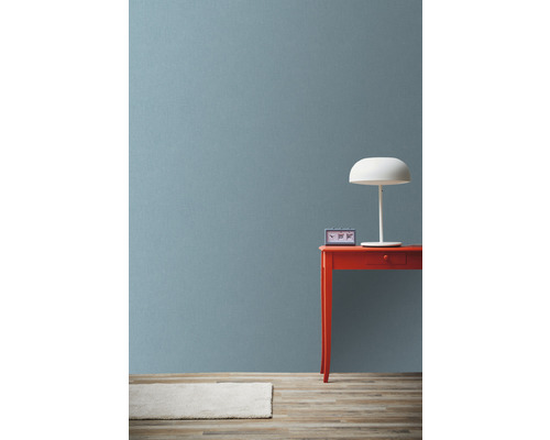 Scène avec table rouge, lampe blanche et horloge devant un mur