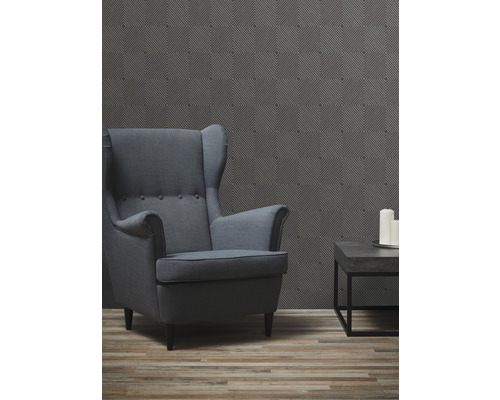 Salon avec fauteuil à oreilles, table basse et papier peint à motifs