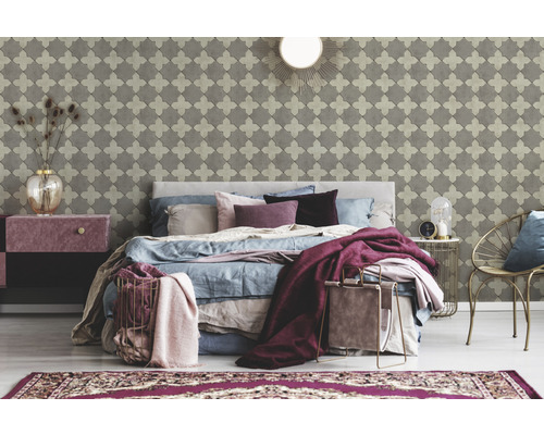 Chambre avec papier peint à motifs, lit, table de chevet et accessoires décoratifs pour une ambiance cosy.