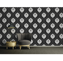 Dekoratives Zimmer mit schwarzer Tapete mit weißem Muster, Sessel und Beistelltisch