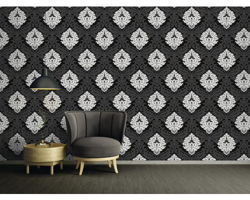 Dekoratives Zimmer mit schwarzer Tapete mit weißem Muster, Sessel und Beistelltisch