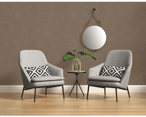 Deux fauteuils gris avec coussins, un miroir rond et une table d''appoint avec une plante dans une pièce.