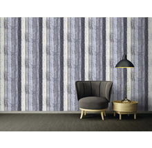 Wohnzimmer mit Sessel, Lampe und Wandtapete in Holzoptik