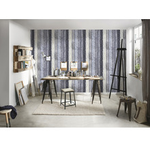 Atelier mit Staffelei, Tisch, Hocker und Regal vor einer Tapete mit Holzoptik