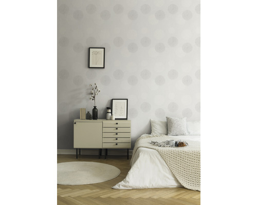 Helles Schlafzimmer mit gemusterten Tapeten, Kommode und Bett