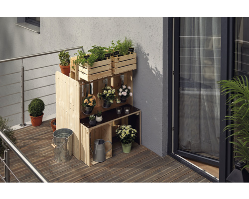 Étagère en bois avec herbes aromatiques et fleurs sur un balcon