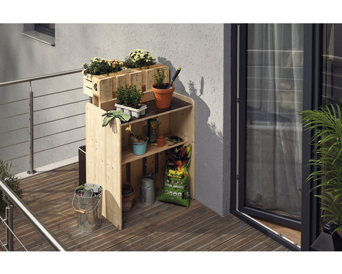 Table de rempotage en bois avec jardinières et accessoires de jardin sur un balcon