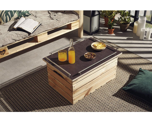 Espace extérieur avec canapé en palettes et table en caisses en bois, décoré avec des boissons et des collations