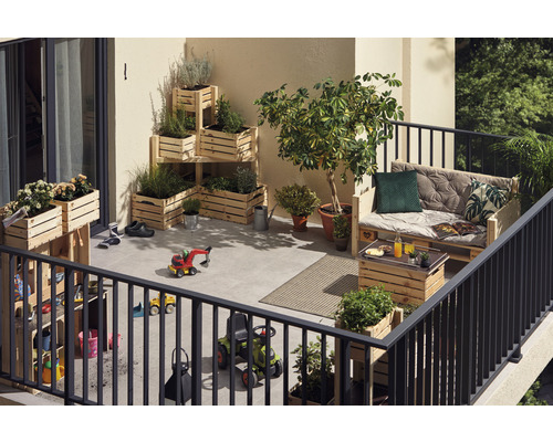 Balcon avec plantes en caisses en bois, palette en bois comme siège et jouets pour enfants