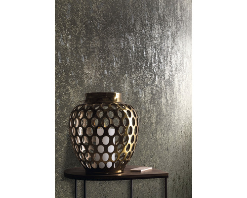 Goldene Laterne mit Kerze auf einem Tisch vor einer strukturierten Wand