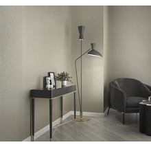 Vue d''intérieur avec console, lampadaire et fauteuil devant un mur tapissé.