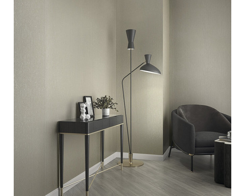 Vue d''intérieur avec console, lampadaire et fauteuil devant un mur tapissé.