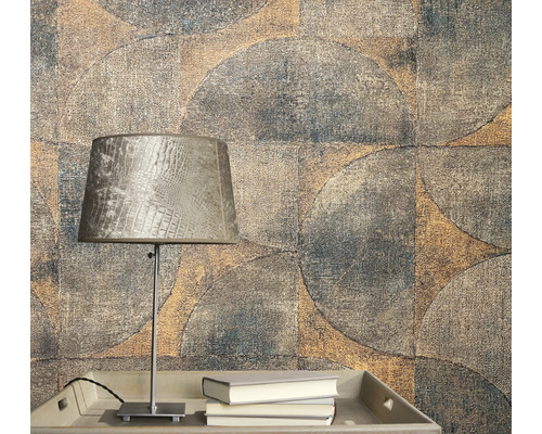 Nahaufnahme einer Wand mit geometrischem Tapetenmuster und einer Lampe auf einem Tisch