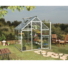 Serre avec plantes et porte ouverte dans le jardin.
