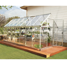 Serre avec étagères à plantes sur terrasse en bois dans le jardin