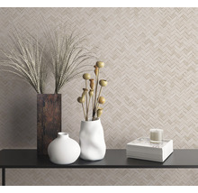 Scène décorative avec des vases, des plantes ornementales, une bougie et des livres sur une étagère devant un mur à motif à chevrons.