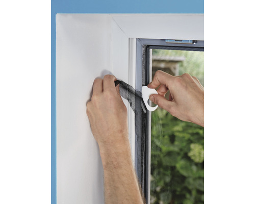 Montage eines Insektenschutzgitters mit Werkzeug am Fensterrahmen