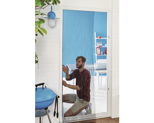 Un homme installe une moustiquaire sur une porte. Un barbecue et des meubles de jardin sont visibles à l''arrière-plan.