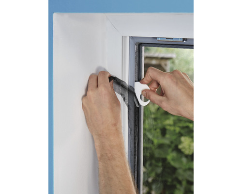 Montage d''une moustiquaire sur le cadre de la fenêtre à l''aide d''un outil