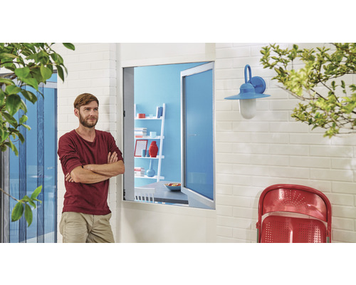 Mann vor einer Terrassentür mit Insektenschutzgitter, Wandleuchte und Stuhl