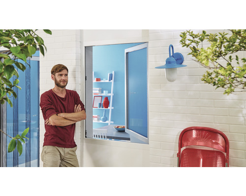 Aussenansicht eines Hauses mit Insektenschutzgitter, Fenster, Wandleuchte und Mann