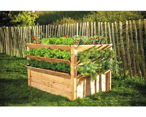Jardinière à étages en bois avec différents légumes dans le jardin.